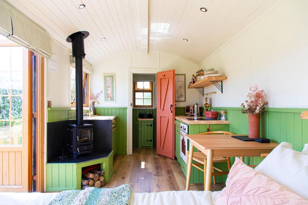 a kitchen with a table and a stove in a room at The Hut at Pengelli in Nelson