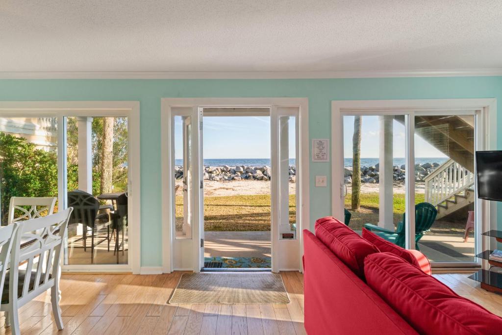 ein Wohnzimmer mit einem roten Sofa und Glasschiebetüren in der Unterkunft The Seaclusion Too - 300 Seventh Street in Saint Simons