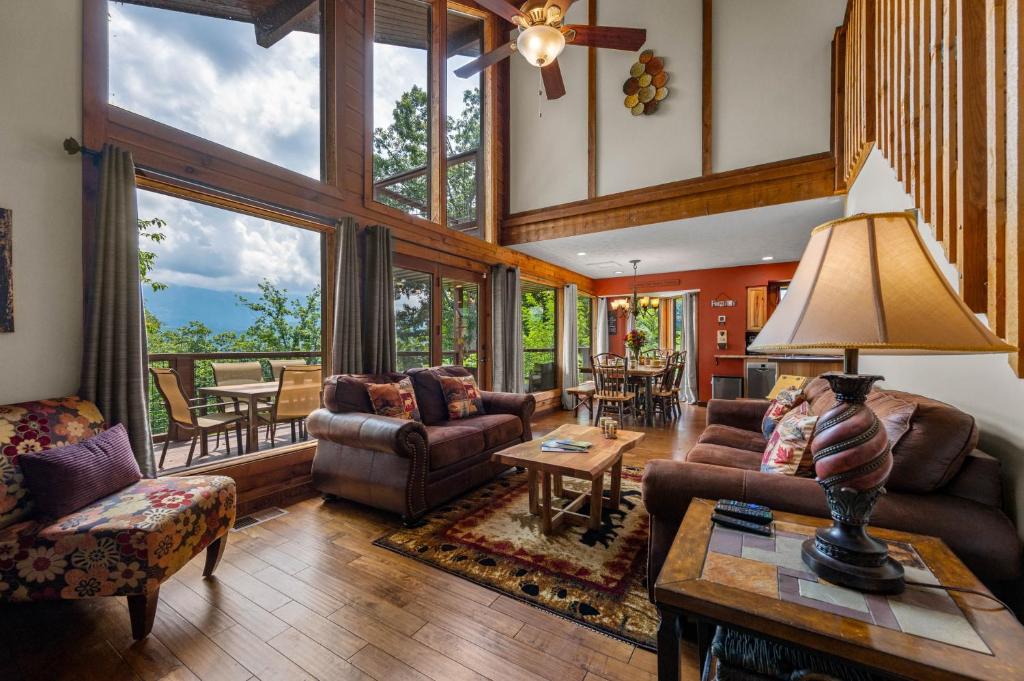 uma sala de estar com mobiliário e uma grande janela em Twinflower Summit - Incredible views, pet friendly! em Gatlinburg