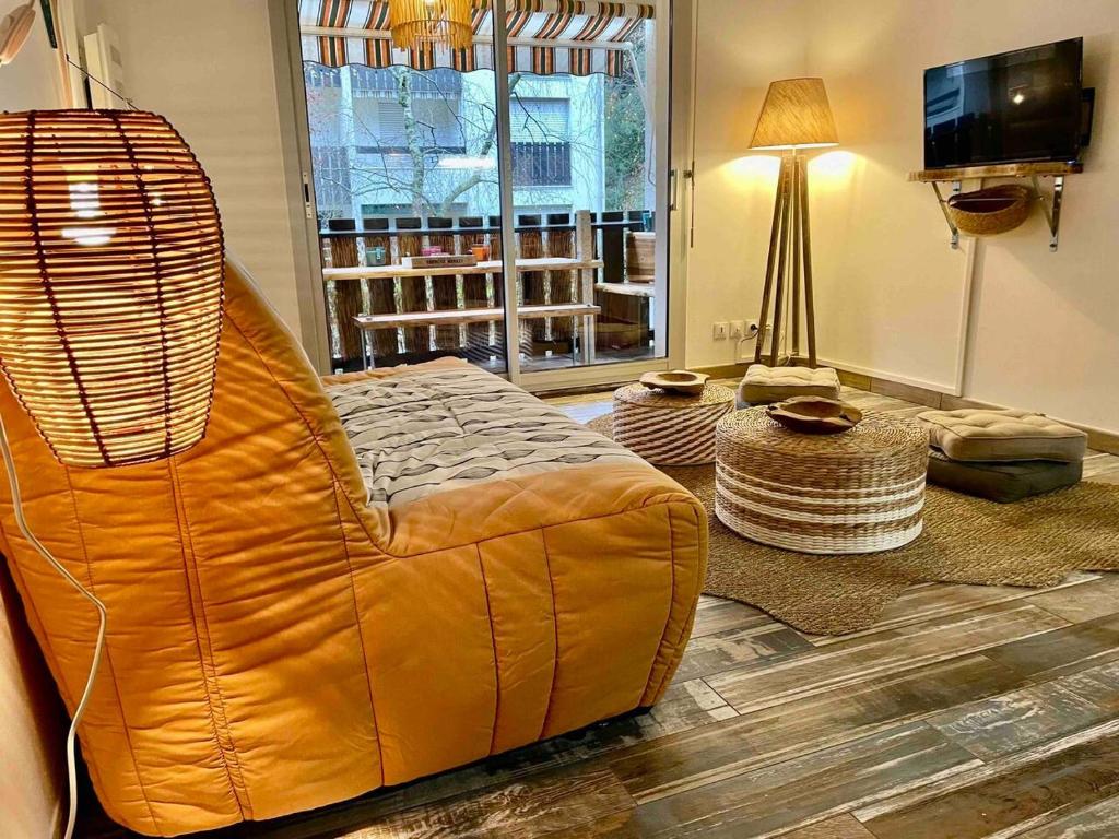 un salon avec un canapé en cuir brun et une télévision dans l'établissement Studio Cosy Tout Confort - 180m Plage - Parking, à Saint-Georges-de-Didonne