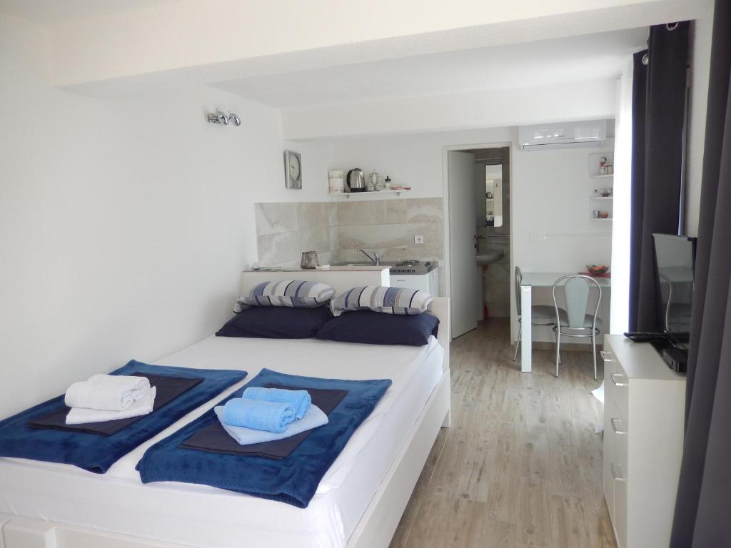 a bedroom with a large white bed with blue pillows at New studio app for 2 in Babino Polje