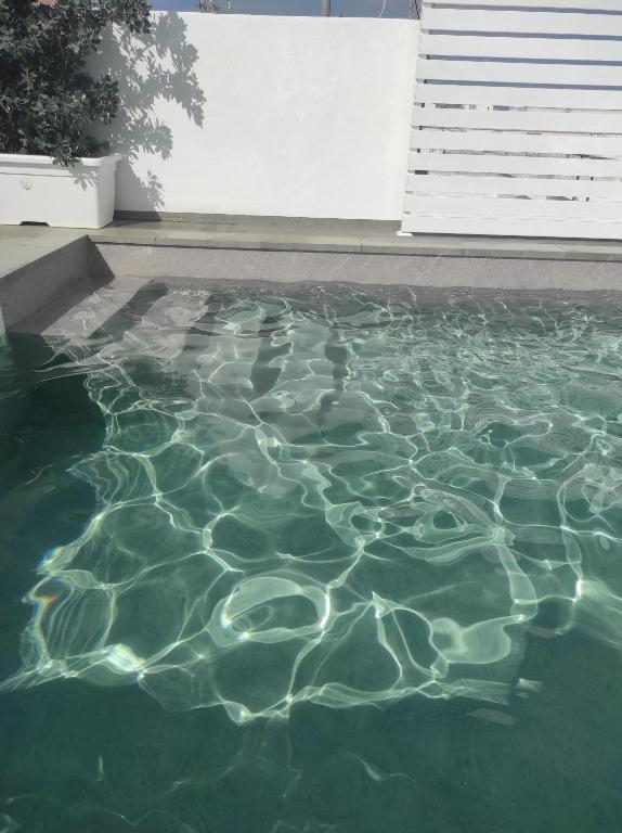 Una piscina con agua verde con luces. en Apartamentos turísticos CASA de los BALCONES, en Chipiona