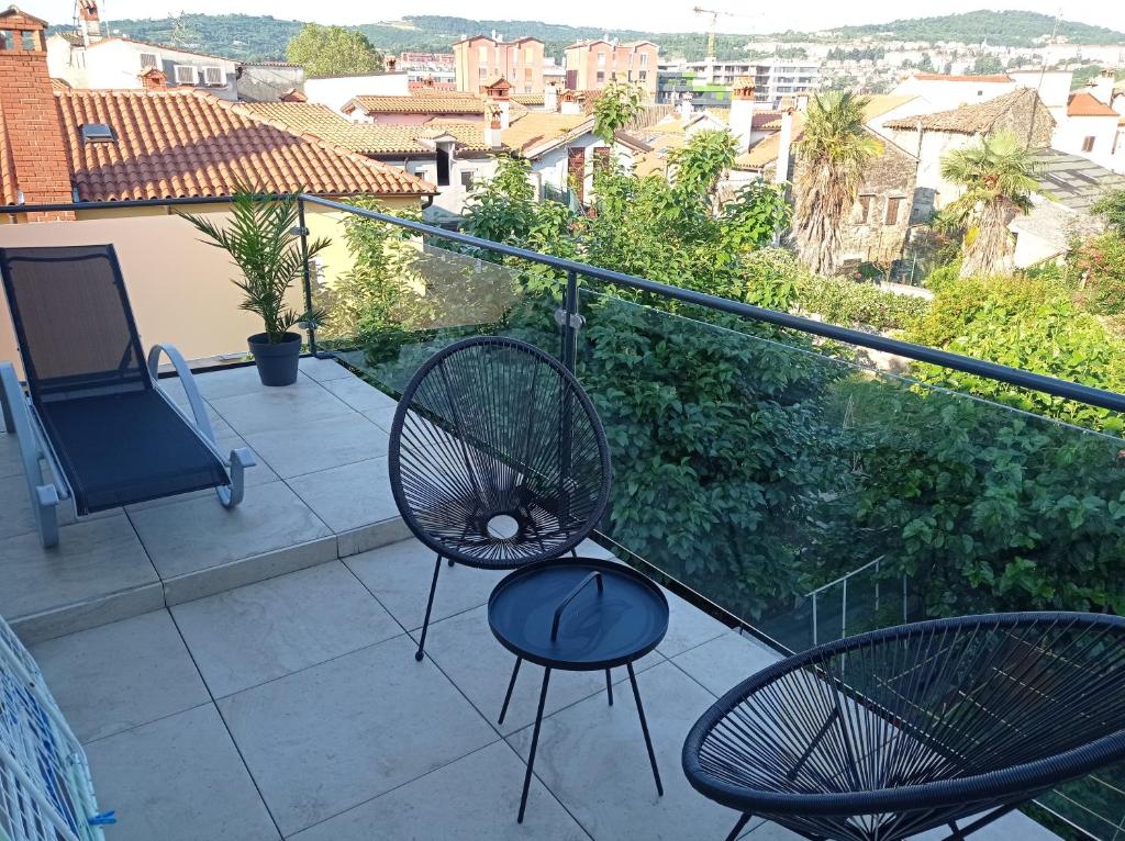 a balcony with chairs and a view of a city at Apartmaja Eva in Pia in Koper