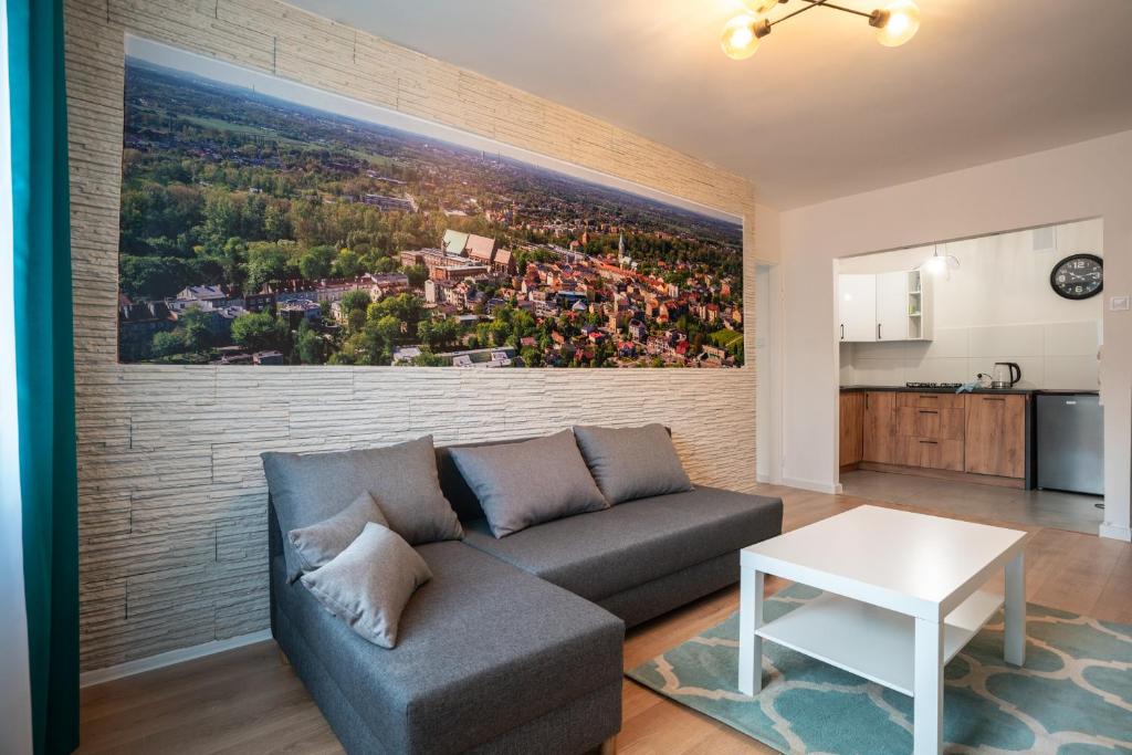 sala de estar con sofá y una pintura en una pared de ladrillo en SKY Apartment 2, en Oświęcim
