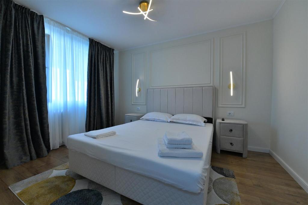1 dormitorio con cama blanca y ventana en Apartament de lux Moghioros Park, en Bucarest