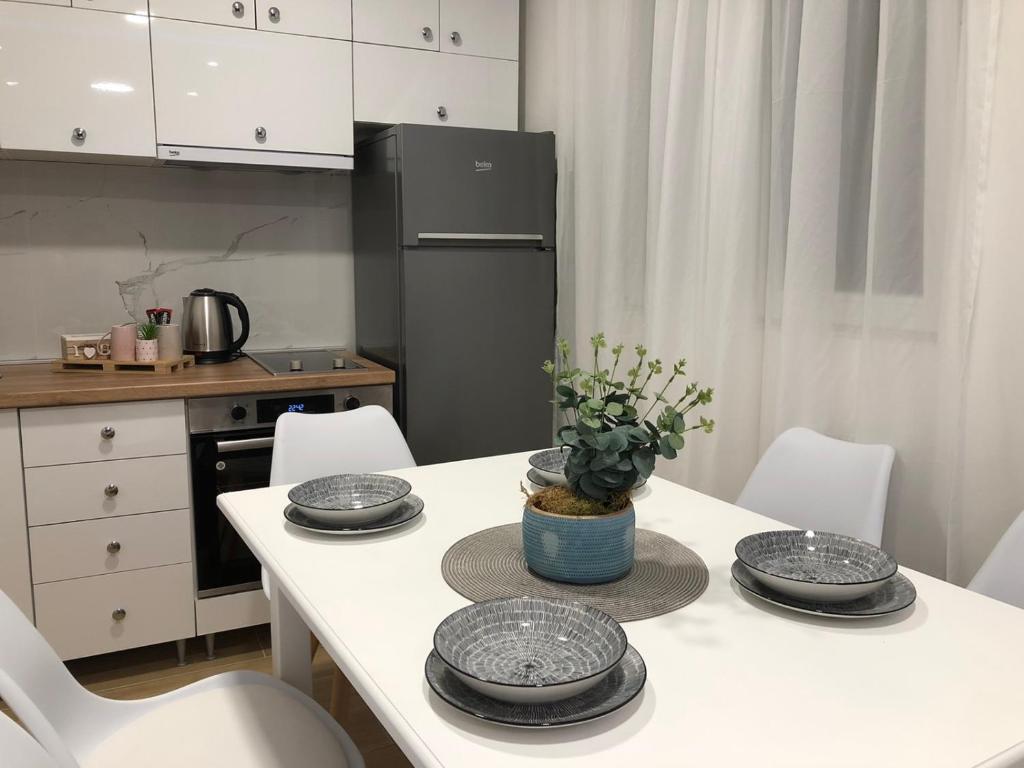a kitchen with a table with plates and a refrigerator at Gargovic Apartments in Budva