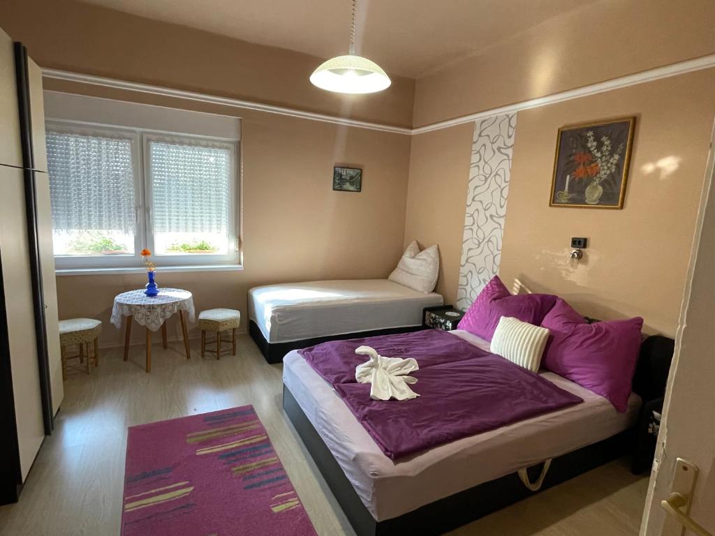 ein Schlafzimmer mit einem Bett, einem Sofa und einem Tisch in der Unterkunft Ravasz Apartman in Balatonboglár