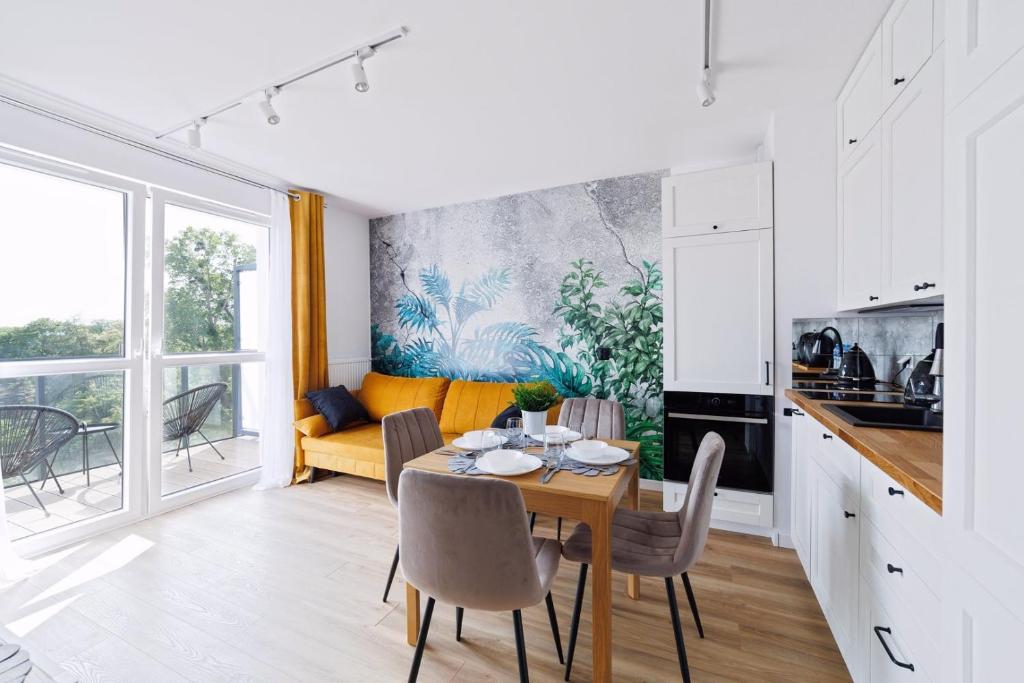 a kitchen and dining room with a table and chairs at Apartament Baltic Dream ProstyWynajem Gdańsk Brzeźno in Gdańsk
