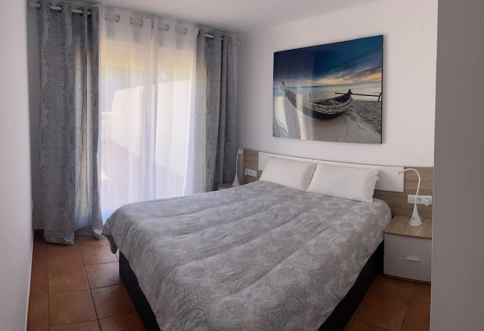 オリーバにあるOliva Nova Golf, Met & Beachのベッド付きのベッドルームとボートの写真