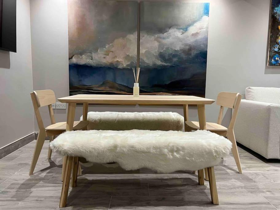 einen Tisch und Stühle mit einem Gemälde an der Wand in der Unterkunft “The Art House 6” Galway, Woodquay in Galway