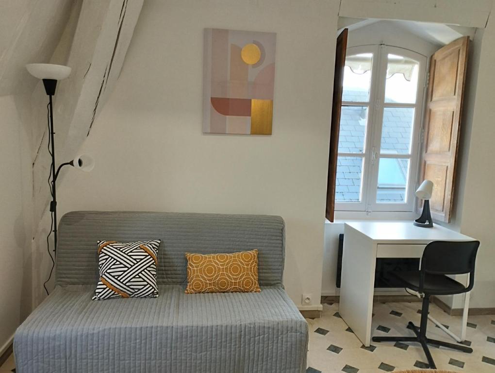sala de estar con sofá y escritorio en Studio Cosy en centre ville, en Arpajon