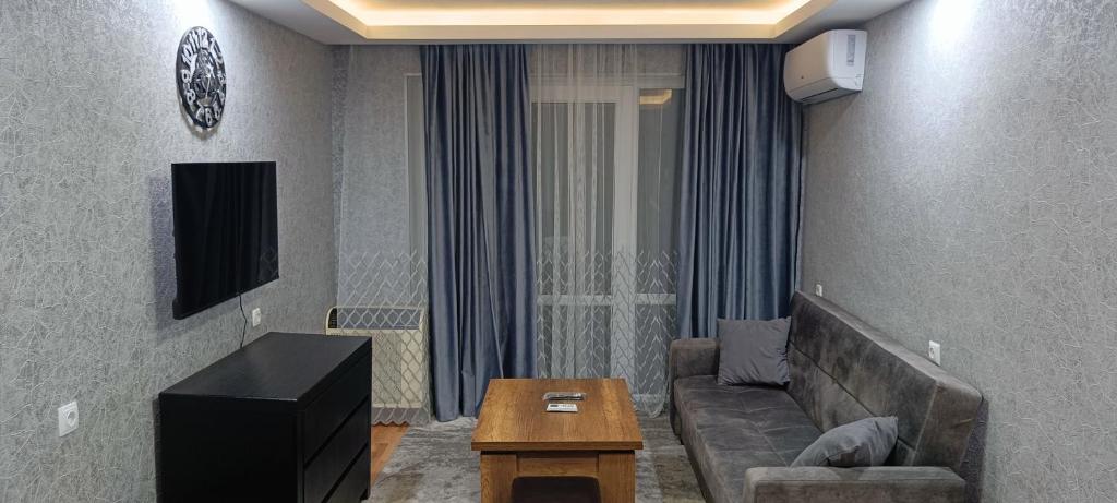 un salon avec un canapé et une table dans l'établissement Borjomi Likani Apartment, à Bordjomi