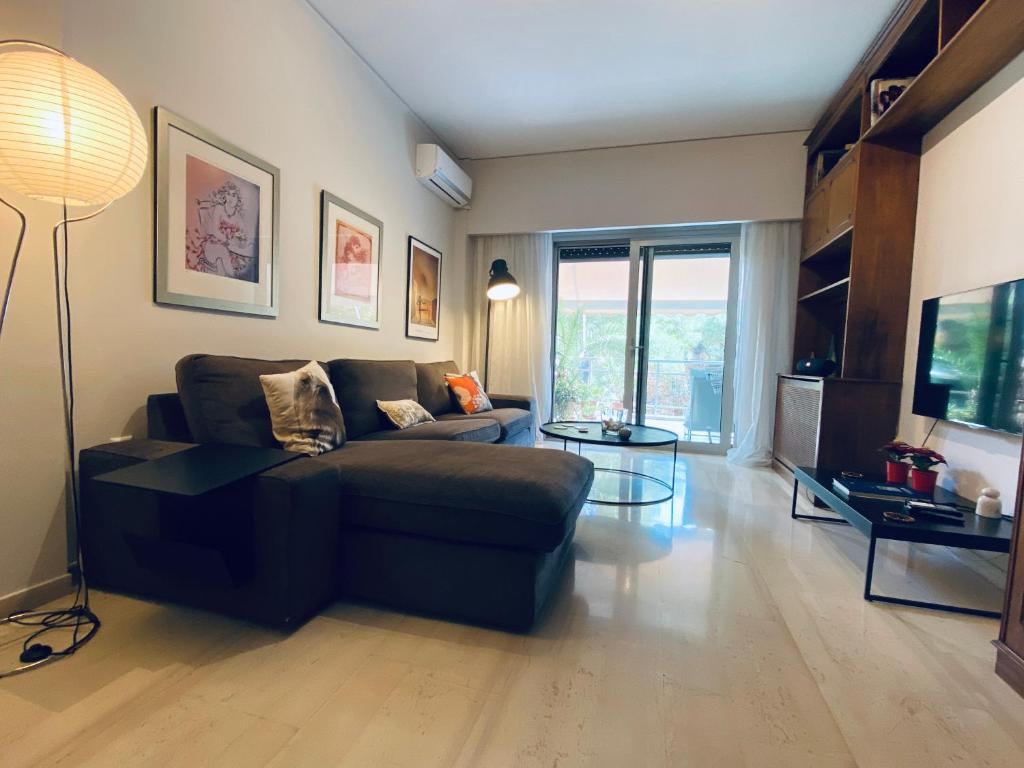 salon z kanapą i stołem w obiekcie Athens Riviera Garden Views Apartment #Unoblu w Atenach