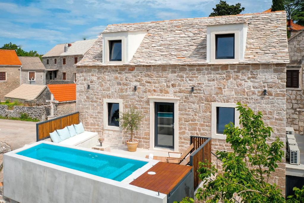 a brick house with a swimming pool in front of it at She House - built for pleasure - Island of Brač in Gornji Humac