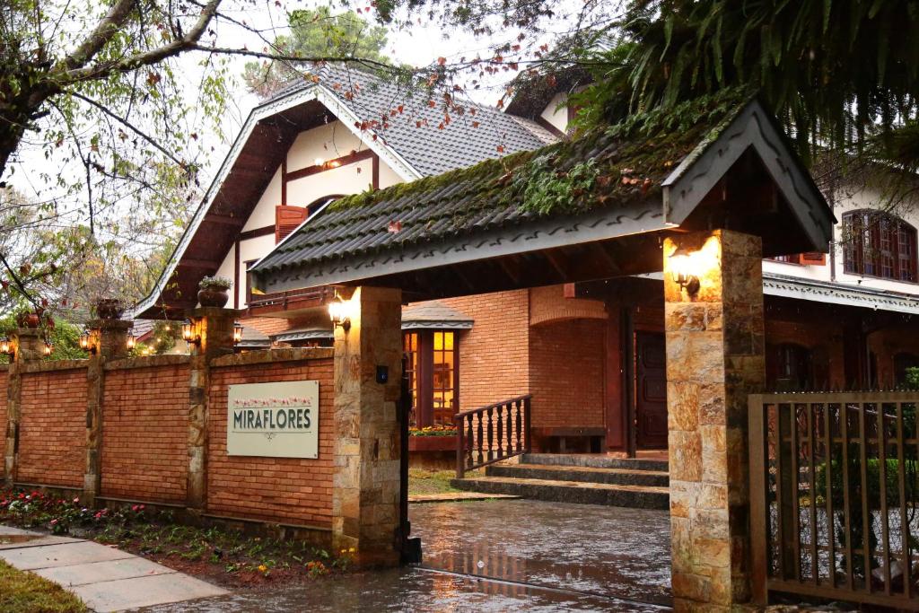 Una casa bajo la lluvia con un cartel. en Pousada Miraflores, en Campos do Jordão