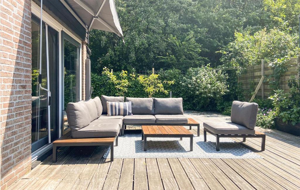 un patio con sofá, 2 sillas y una mesa en Stunning Home In Noordwijk With Wifi, en Noordwijk