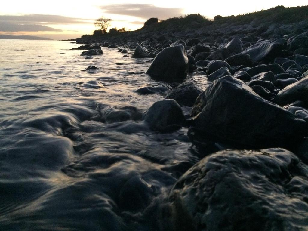 un gruppo di rocce sulla riva di una spiaggia di Tower Beach a Galway