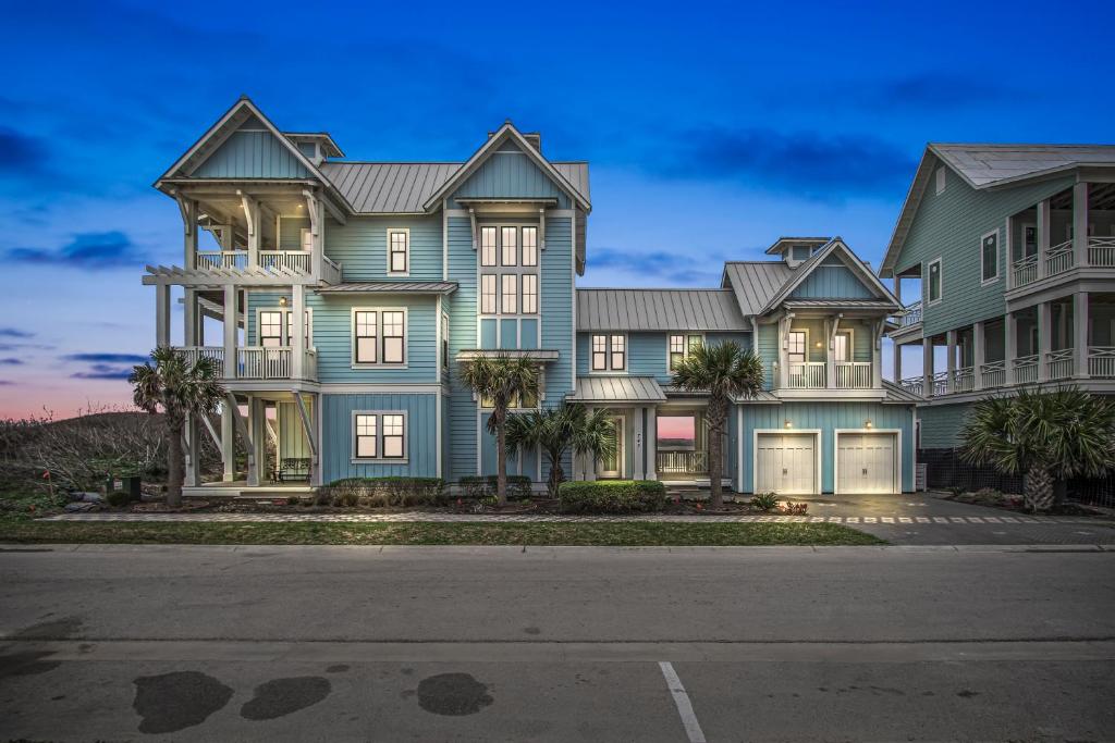 a large house with palm trees in front of it at Luxury house with wet bar, outdoor shower, steps from Gulf in Port Aransas