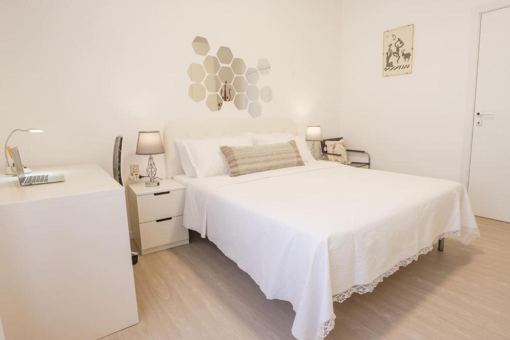 biała sypialnia z białym łóżkiem i umywalką w obiekcie FIORINA w mieście Saronno
