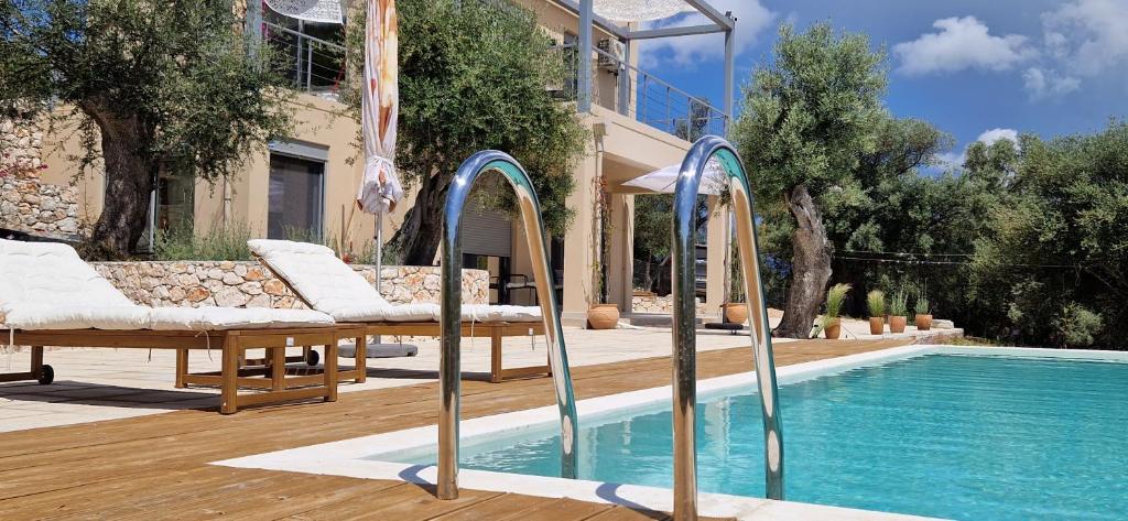 a house with a swimming pool next to a building at Villa Maya Lefkada in Évyiros