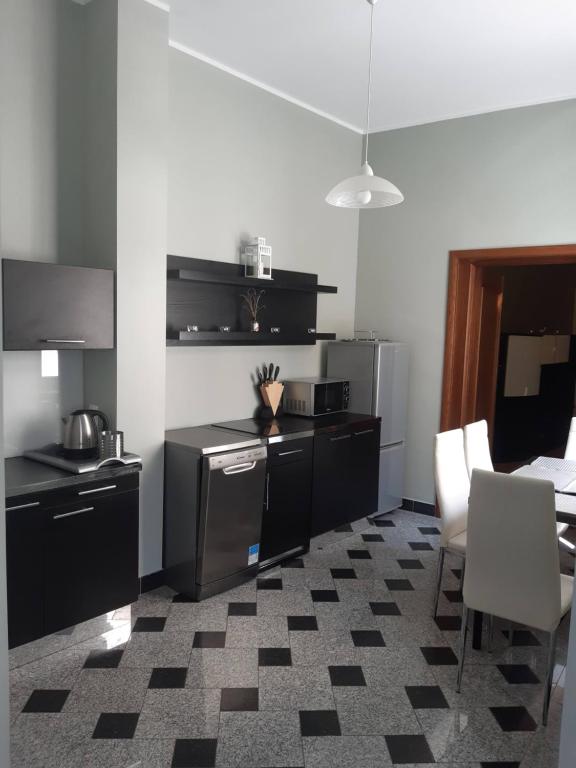 eine Küche mit schwarzen Geräten sowie einem Tisch und Stühlen in der Unterkunft apartament in Posen