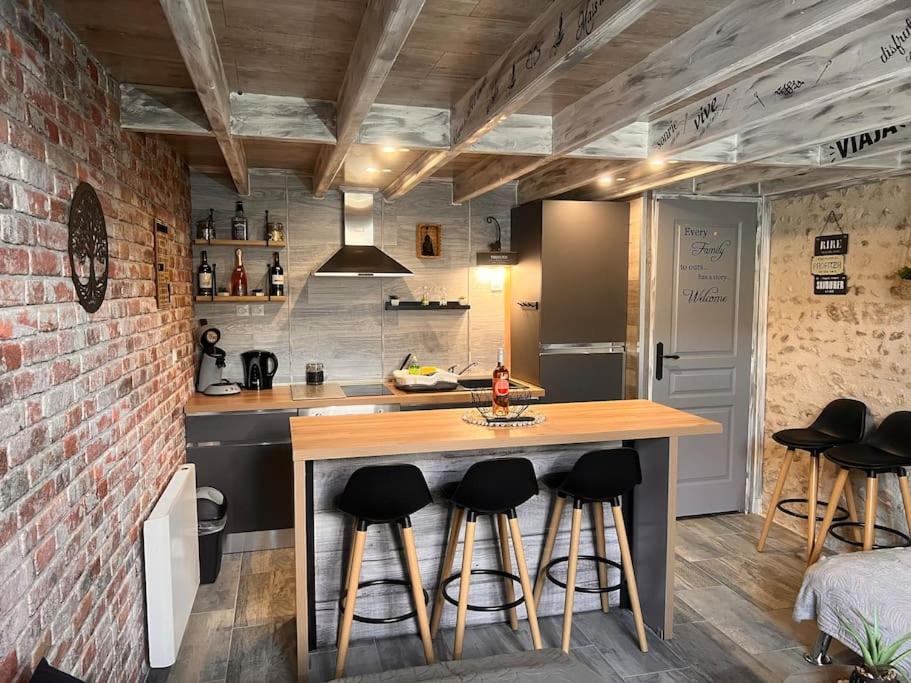 a kitchen with a counter with stools around it at Top Loft Perles 4 des Châteaux in Mer