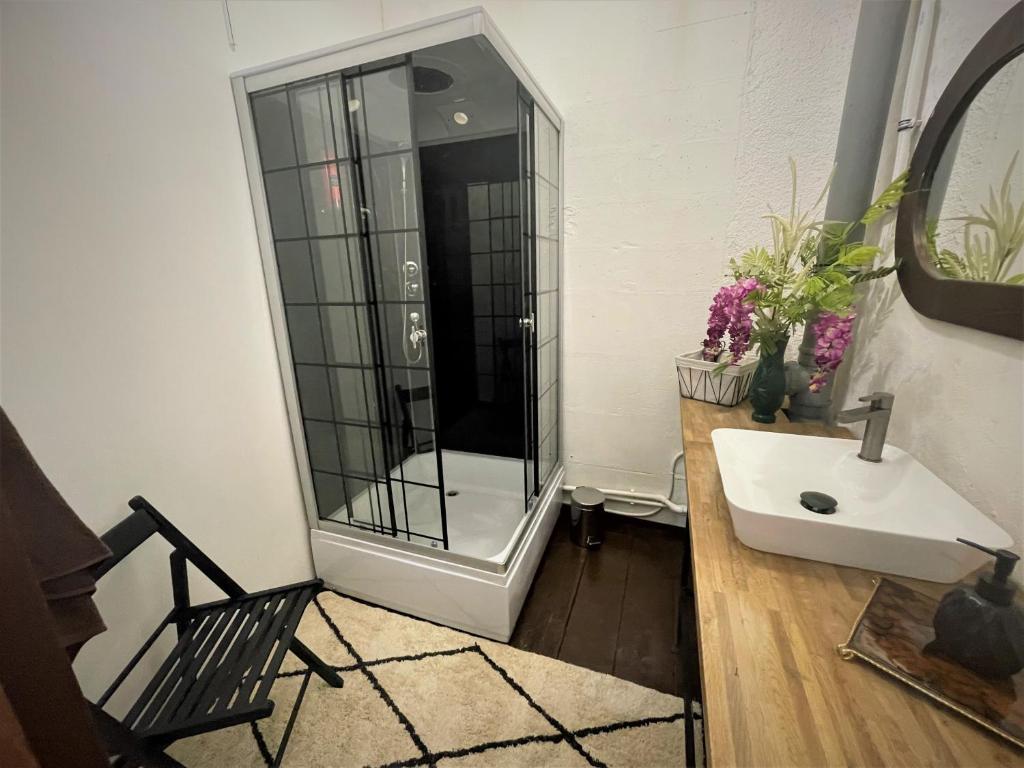 uma casa de banho com um lavatório e uma cabina de duche em vidro. em Urban Van Glamping Riga em Riga