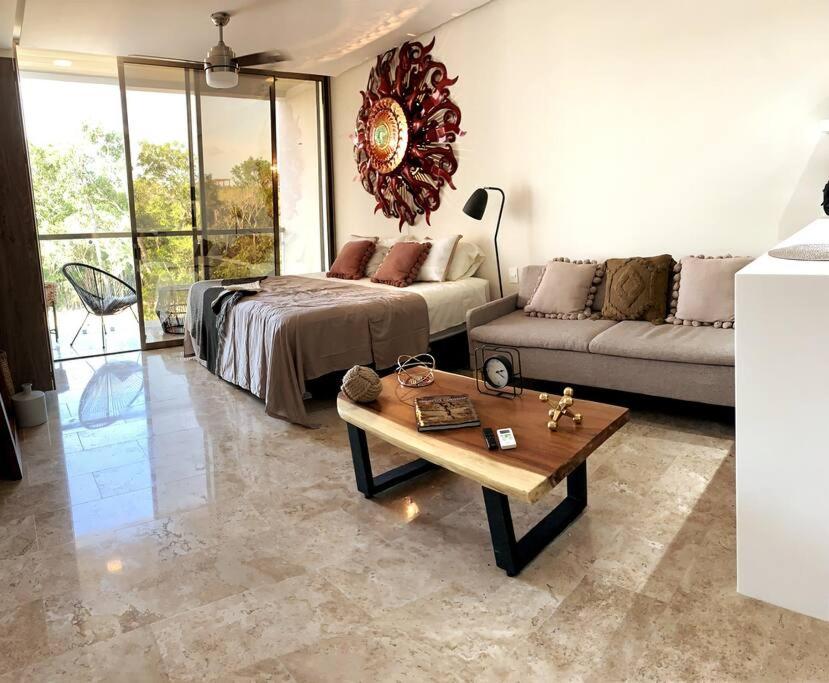 ein Wohnzimmer mit einem Bett, einem Sofa und einem Tisch in der Unterkunft LUXURY CONDO EXCLUSIVE ¨ALDEA ZAMA¨ in Tulum