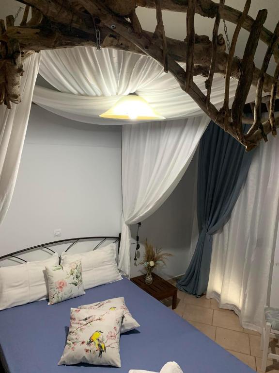 a bedroom with a blue bed with white curtains at Mary's apartment in Stomio