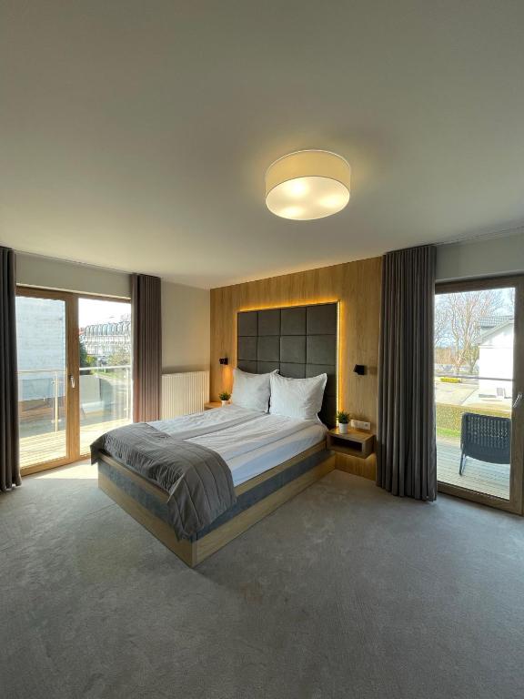 a bedroom with a large bed and a large window at Sea Resort 1 & Spa in Władysławowo