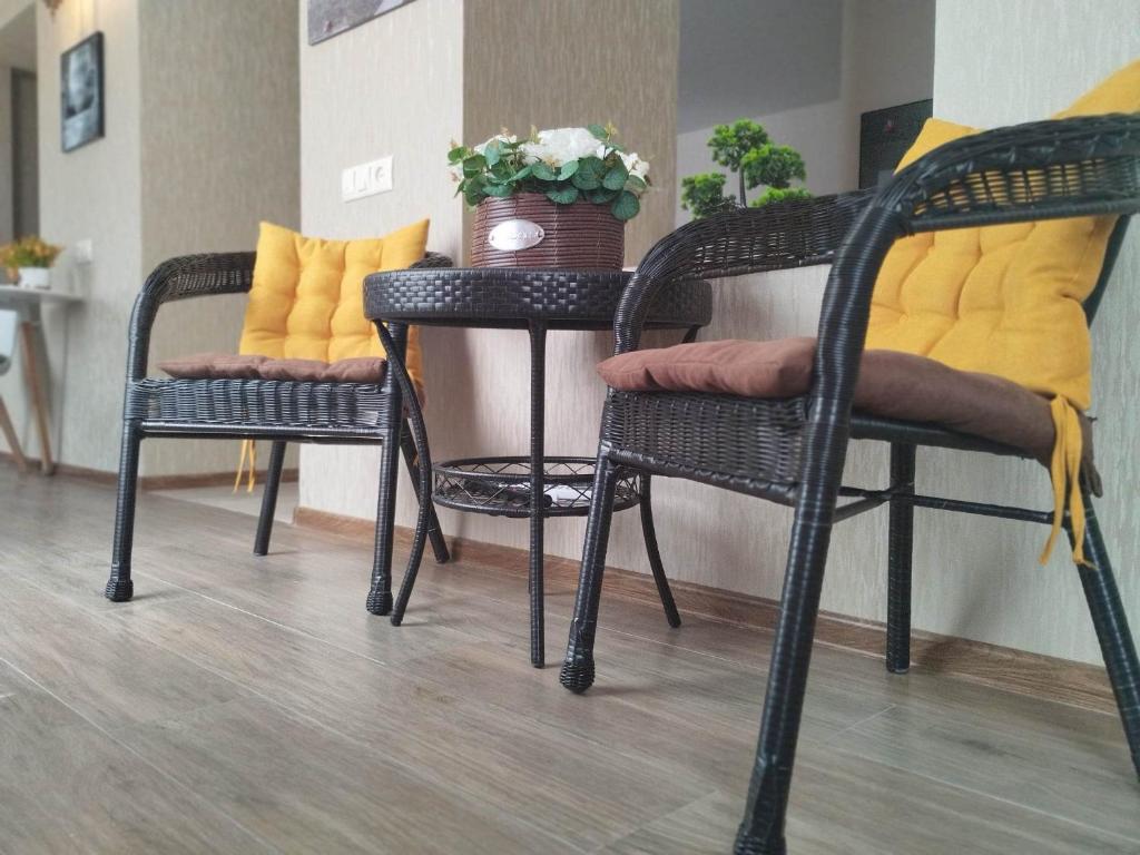 2 chaises et une table avec un vase. dans l'établissement Metekhi Apartments, à Tbilissi