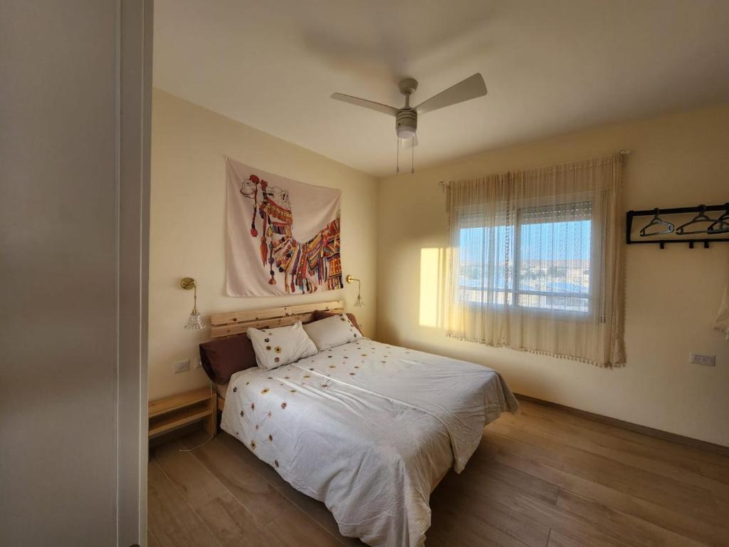 Schlafzimmer mit einem Bett und einem Fenster in der Unterkunft מדברא - צימר בירוחם in Jerocham