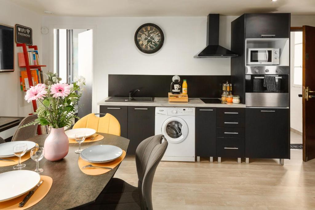 a kitchen with a table and a washing machine at My Evening Break- Appartement cosy proche Disney et Paris in Noisy-le-Grand