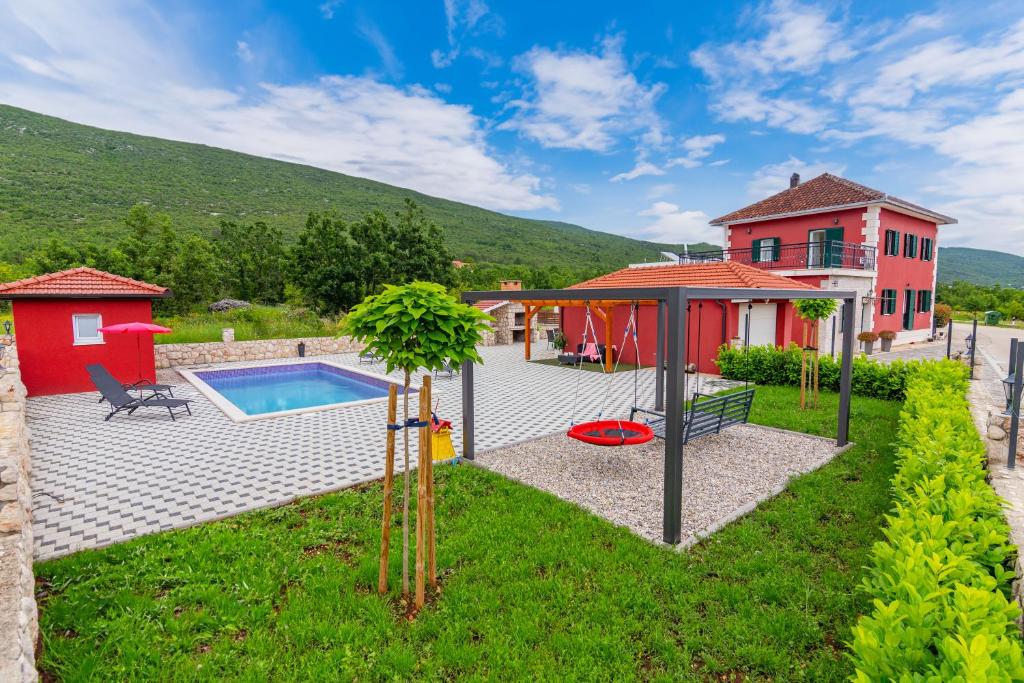 a backyard with a pool and a house at Villa Rubin in Slivno