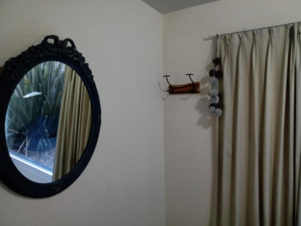 um espelho pendurado numa parede ao lado de uma janela em Alegra Centro em San Martín de los Andes