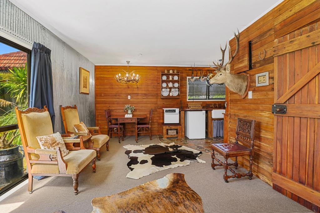 a living room with a deer head on the wall at Cosy Central Cottage in Rotorua