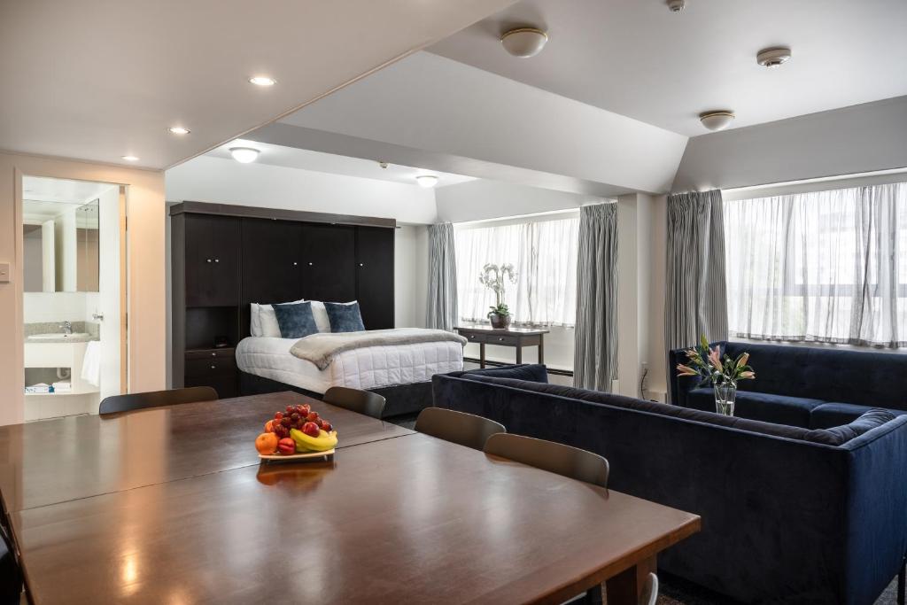 a living room with a table and a bedroom at Bay Plaza Hotel in Wellington