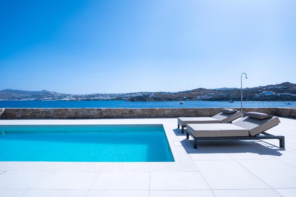 une piscine avec une chaise longue et une piscine dans l'établissement Myko Villa by Bestofmikonos, à Ornos