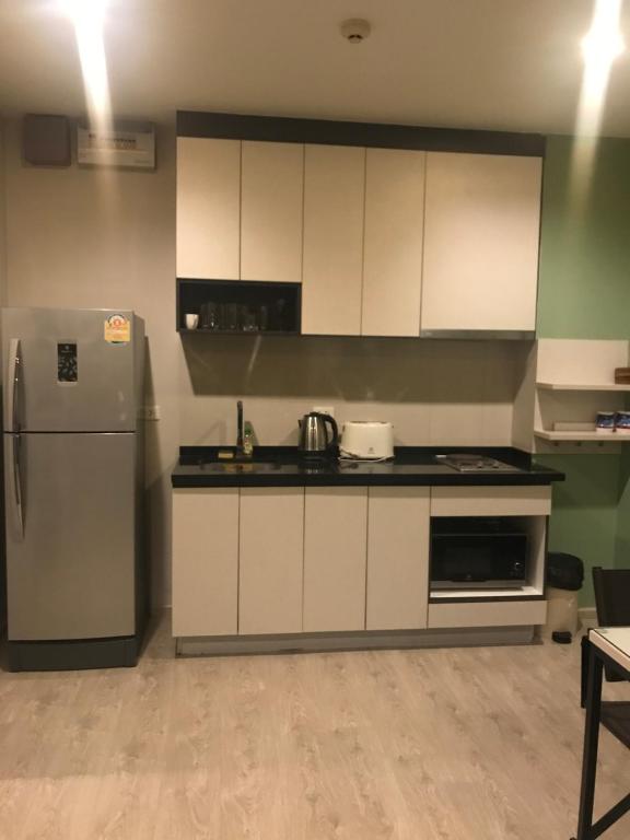 a kitchen with white cabinets and a refrigerator at The base central for family by bobby in Pattaya Central