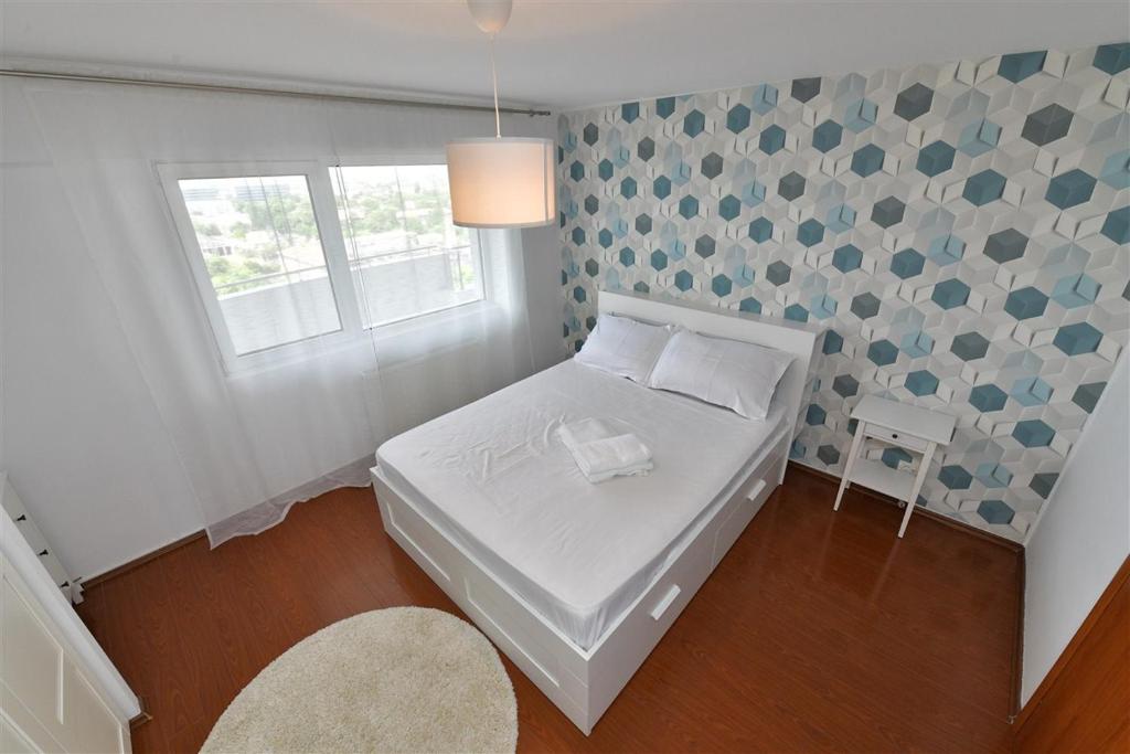 a small bedroom with a white bed and a window at Apartament LUX 1 Mai Pod in Bucharest