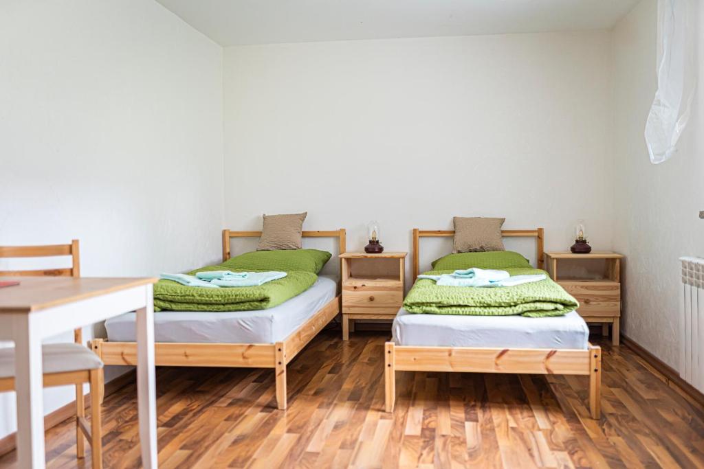 2 camas individuales en una habitación con mesa en Zimmervermietung Familie Schuster, en Wusterhausen
