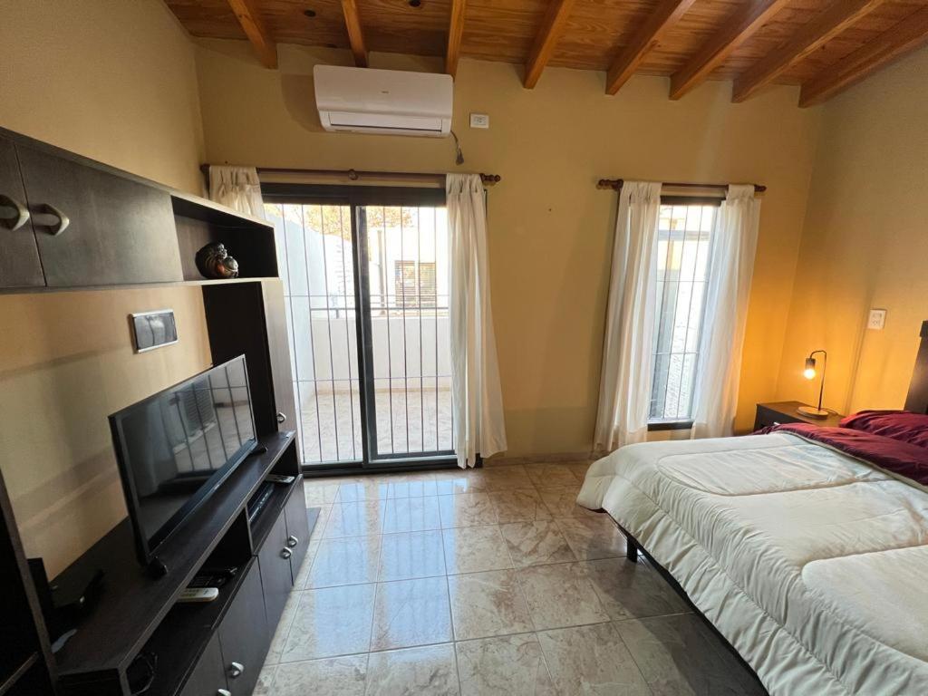 1 dormitorio con 1 cama y TV de pantalla plana en Departamento Terruños en Tunuyán