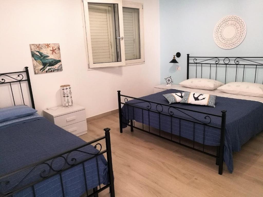 Lido ConchigliaにあるA Casa di Nadiaのベッドルーム1室(ベッド2台、窓付)