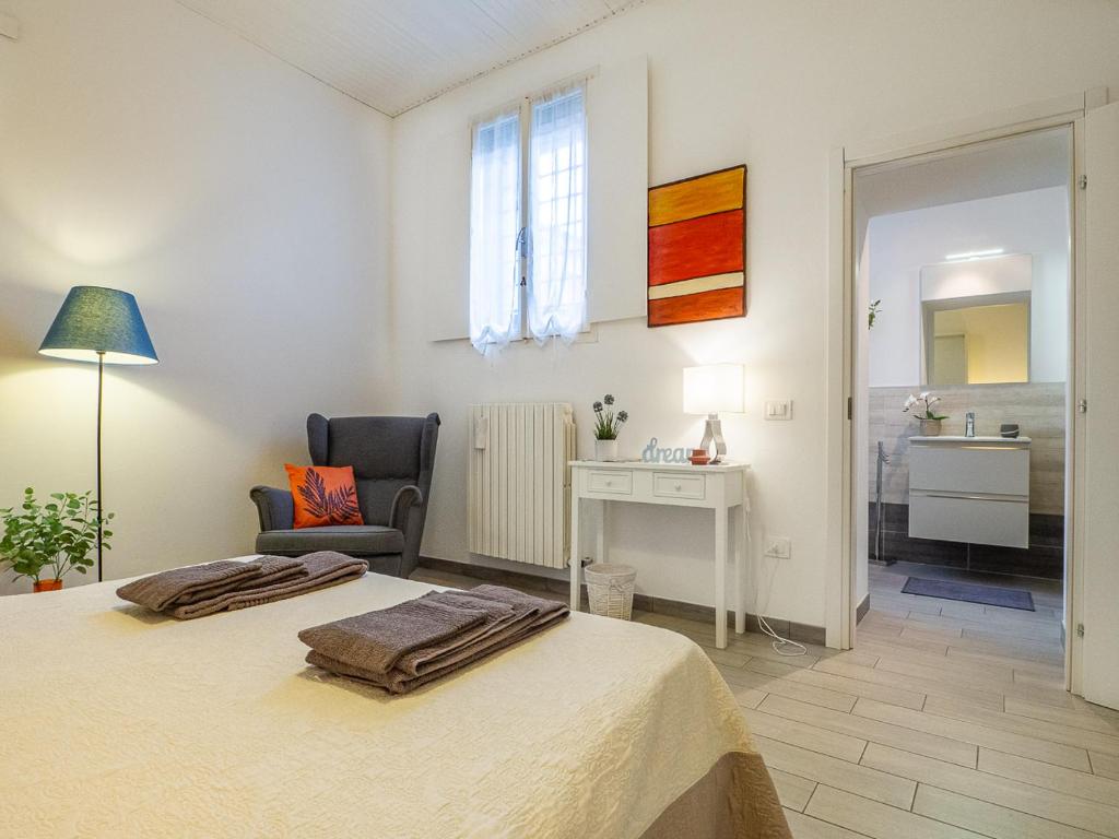 a bedroom with a bed and a desk and a chair at Loveflat - scopri Ferrara in bicicletta in Ferrara