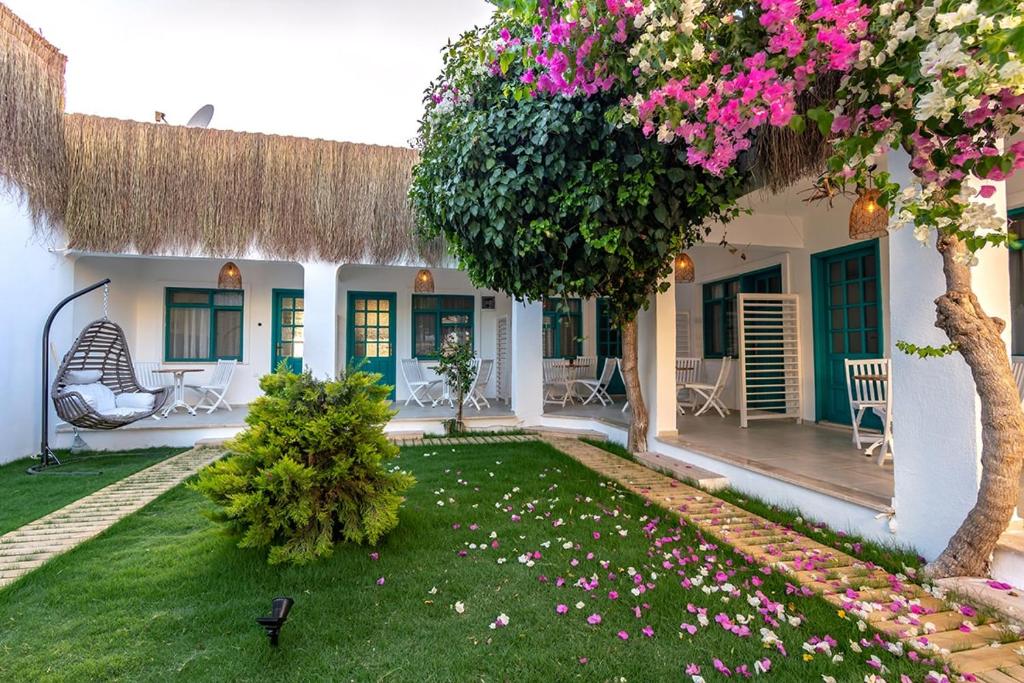 ein Haus mit einem Hof mit rosa Blumen in der Unterkunft Avlu Boutique Hotel in Datca