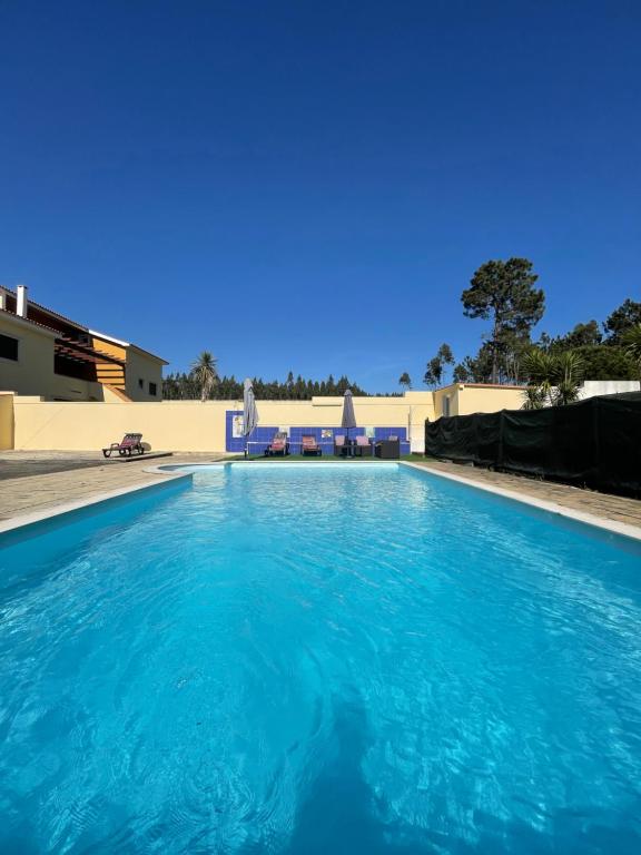 a large swimming pool with blue water at Paraíso do Quim in São Martinho do Porto