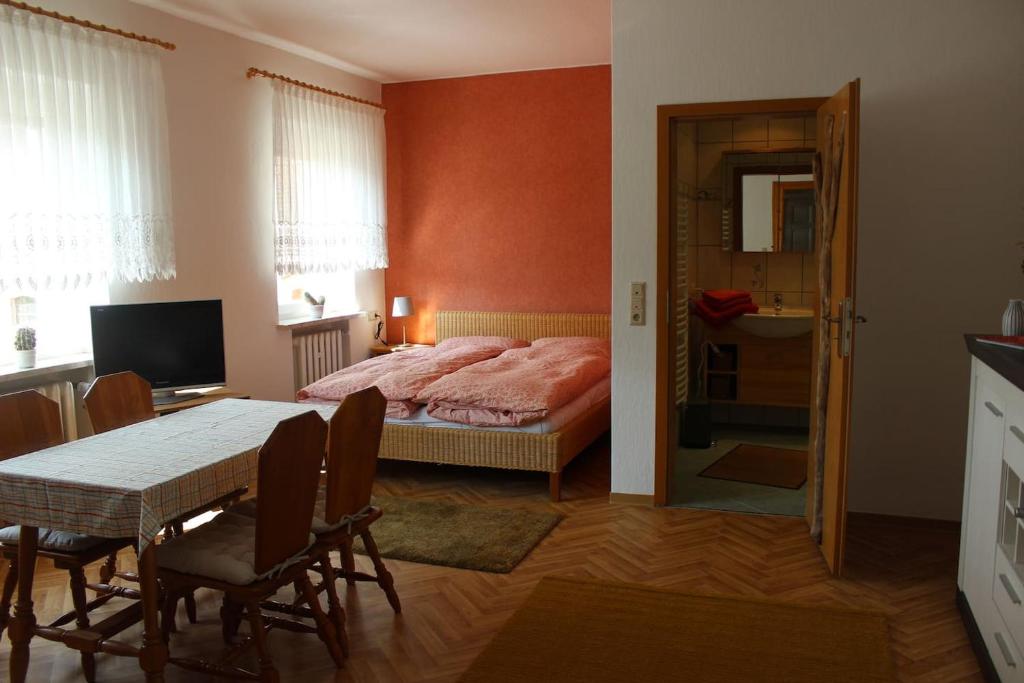 1 dormitorio con 1 cama, mesa y sillas en Amselwohnung 