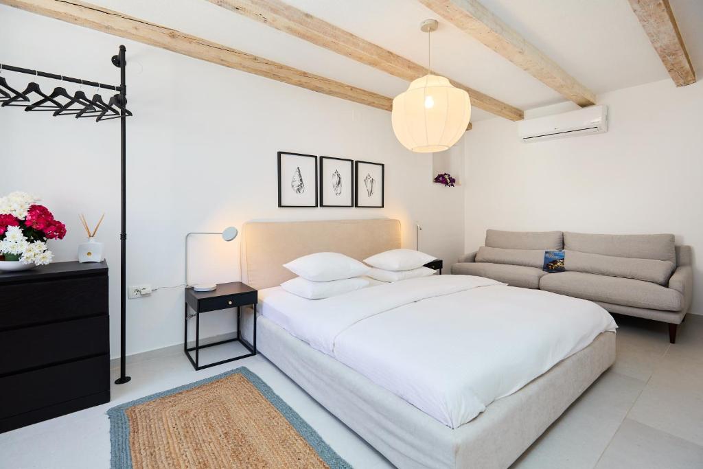 um quarto branco com uma cama e um sofá em Stone Elegance em Dubrovnik