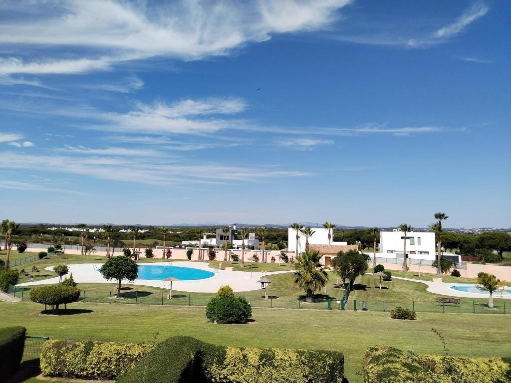 vistas a una piscina en un parque en El Balcón del Novo -Novo Sancti Petri- Luxury 3 Bedrooms - Piscina y Pista Padel, en Chiclana de la Frontera