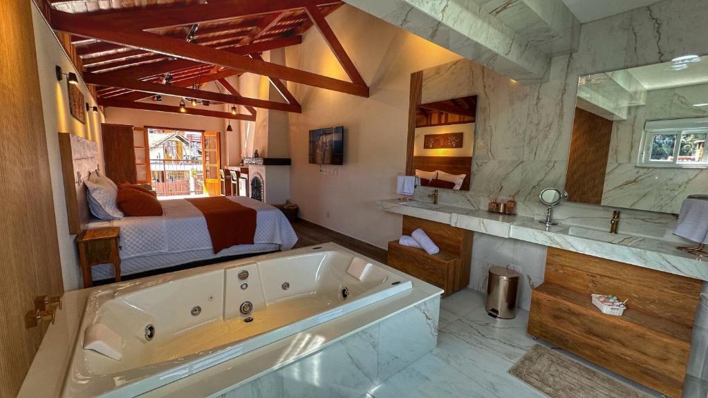 uma grande casa de banho com uma banheira e uma cama em Monte Verde Lofts Araucária em Monte Verde